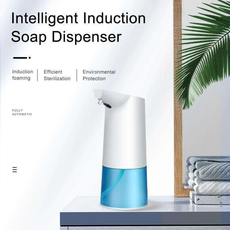 Automatic touchless foam soap dispenser placed on a countertop next to towels and a plant, highlighting its sleek design.