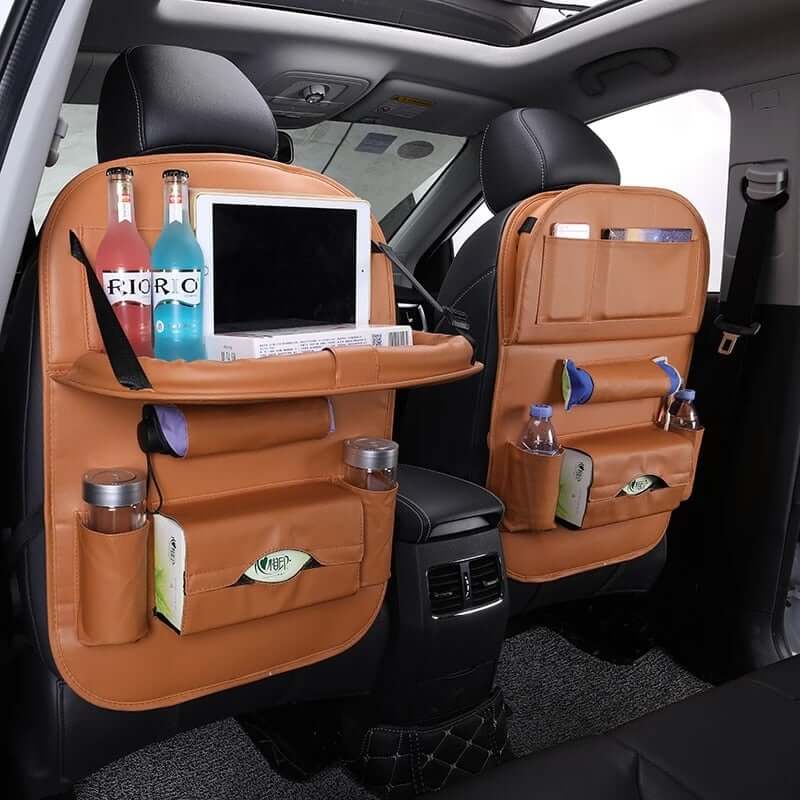 Leather car seat organizer with tray displayed in a car, featuring compartments for drinks and tablets.