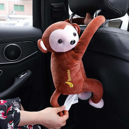 Hanging monkey tissue holder attached to car seat, providing fun and functional tissue access.