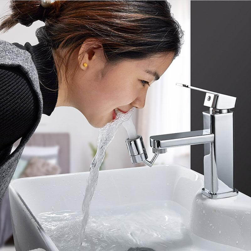 Person using a universal faucet splash guard to drink water from a sink efficiently.