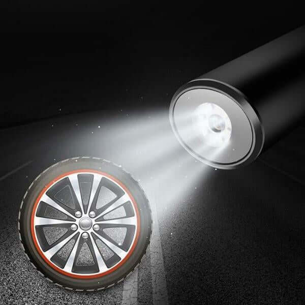 Mini digital tire air pump illuminating a tire on a dark road with a powerful LED light.