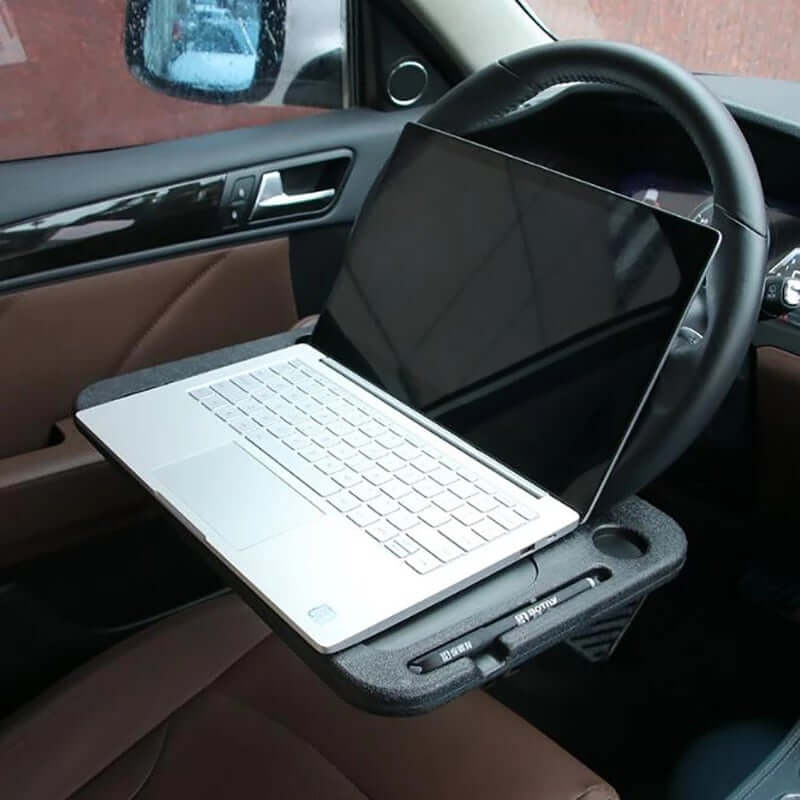 Portable car steering wheel tray with laptop for convenient work setup in vehicle.