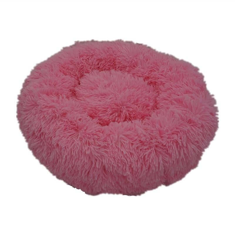 Calming donut bed for pets in soft pink faux fur, perfect for keeping dogs and cats cozy and comfortable.